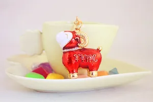 Gros plan d'un mignon porte-clés mouton en émail rouge avec collier en strass brillant