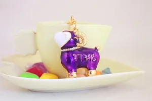 Gros plan d'un porte-clés décoratif en émail violet en forme de mouton avec des strass fins