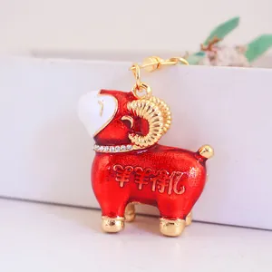 Porte-clés mignon bélier rouge avec strass scintillants et élégantes cornes dorées.