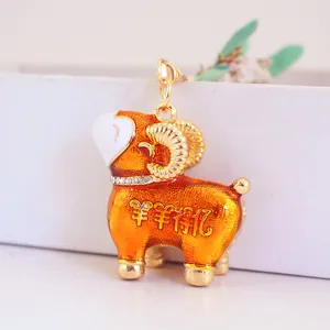 Porte-clés mouton en émail orange avec des strass brillants et des caractères porte-bonheur.