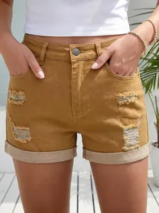 Pantaloncini di jeans gialli strappati da donna con dettagli usurati e orlo risvoltato