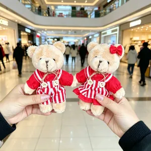 Close-up of a pair of cute plush teddy bear keychains in red striped outfits.