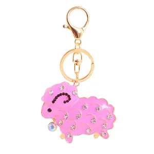 Close-up detail of cute pink rhinestone sheep animal keychain with a shiny gold clasp