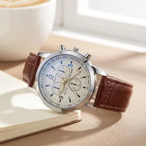 Detail of men's quartz watch with brown leather strap and decorative three-eye dial.