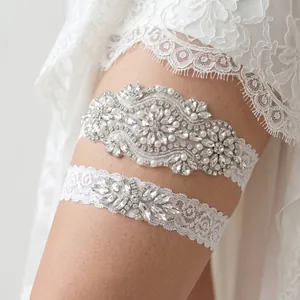 Detail shot of white bridal lace garter set with sparkling rhinestones and pearls