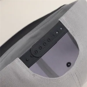 Close-up detail of the adjustable black snapback strap on a grey textured baseball cap.