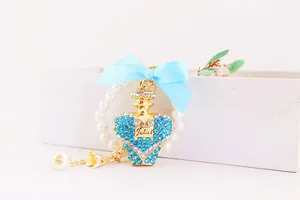 Detailed close-up of creative crystal perfume bottle keychain with blue bow and pearl ring