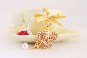 Close-up of luxurious golden crystal perfume bottle keychain with bow and Eiffel Tower