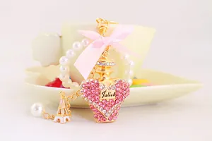 Close-up of pink rhinestone perfume bottle keychain with bow and Eiffel Tower