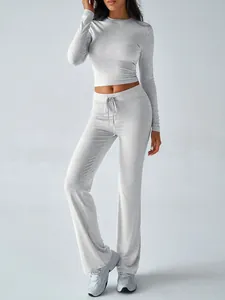 Detail view of a gray sports yoga set featuring a long-sleeved crop top and wide-leg pants