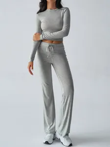Close-up of gray long sleeve crop top and matching drawstring flared yoga pants set