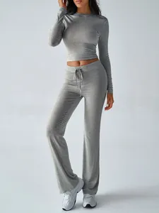 Detail view of grey two-piece yoga set with long sleeve crop top and flared trousers
