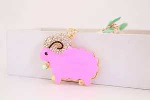 Close-up of cute pink enamel sheep keychain with sparkling rhinestones and gold finish