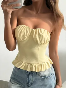 Detail of yellow Y2K strapless top featuring a ruffled hem and pleated bust design