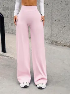 Vista completa di pantaloni da yoga rosa a vita alta con gamba larga in stile Y2K
