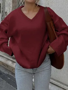 Close-up of wine red V-neck knit sweater with ribbed cuffs and hem details