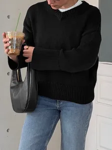 Close-up of black oversized knit sweater with ribbed cuffs and V-neckline detail