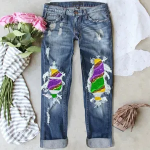 Women's ripped straight leg jeans with colorful tie-dye patches and cuffed hem.
