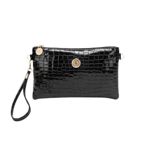 Elegant black glossy crocodile pattern clutch bag with rhinestone gold emblem detail