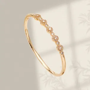 Elegant gold-plated bangle bracelet featuring shimmering zircon-encrusted petal details