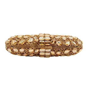 Elegant oval golden evening clutch bag fully encrusted with shimmering rhinestones
