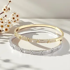 Close-up of gold and silver bangles with petal zirconia and X-pattern accents.
