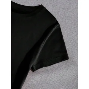 Close-up detail of a minimalist black crew neck t-shirt with high-quality stitching