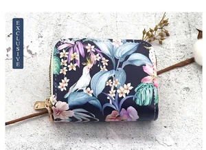 Close-up of a double zipper card holder with a vibrant tropical floral and bird print
