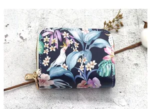 Close-up of a double zipper card holder with a vibrant tropical floral and bird print