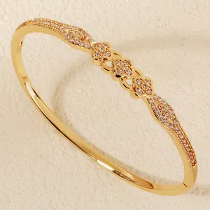 Detailed close-up of a gold-toned flower zircon pavé bangle bracelet for women