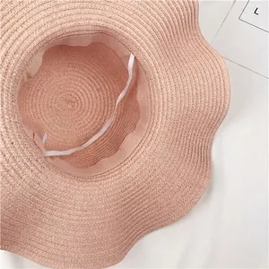 Elegant foldable pink straw sun hat with wavy brim for women summer beach protection
