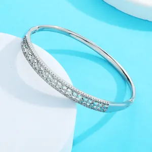 Close-up of silver-tone bangle with intricate petal patterns and pavé zirconia stones.