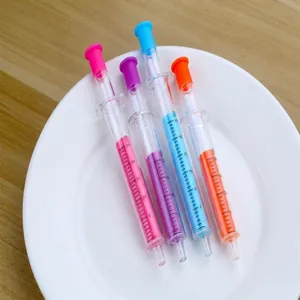 Close-up detail of creative syringe-shaped gel pens in various colors on a white plate