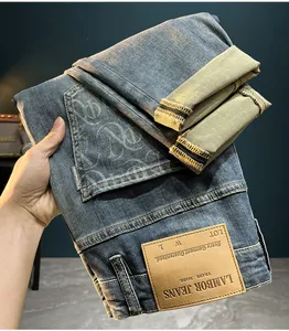 Detailed close-up of men's slim fit vintage washed denim jeans with monogram print