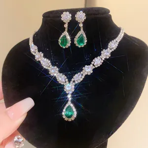 Detailed macro view showing the sparkling emerald green teardrop necklace and earrings set