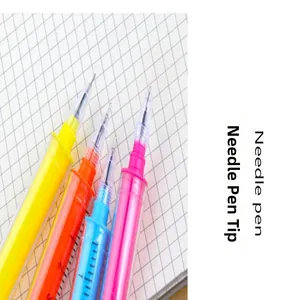 Primo piano di penne gel colorate a forma di siringa con punte ad ago su un taccuino