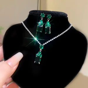 Detail shot of luxury emerald green crystal necklace and earrings set on black display