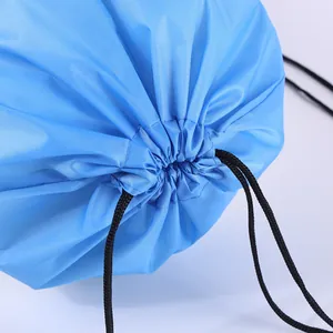 Detailed macro view showing the durable black drawstring closure of a bright blue sports bag