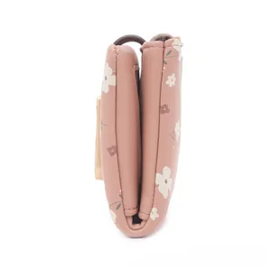 Side profile view of a compact pink floral print folded wallet showing thickness