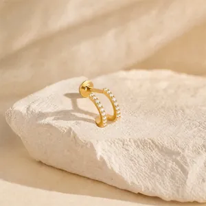 Close-up view of a gold-plated s925 silver double C-shaped stud earring with cubic zirconia