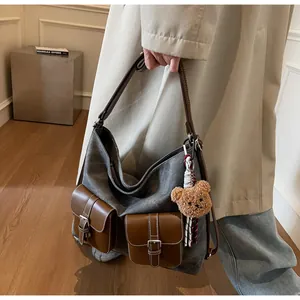 Stylish denim texture hobo handbag with brown leather pockets and cute teddy bear charm