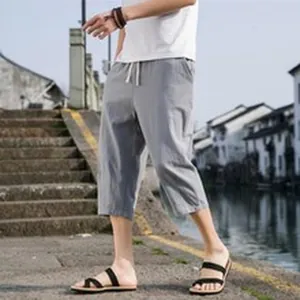 Casual grey cotton linen cropped pants for men worn in an outdoor summer setting