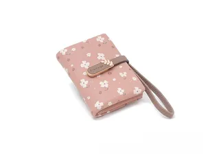 Close-up of a stylish pink floral short wallet featuring a gold leaf buckle and wrist strap