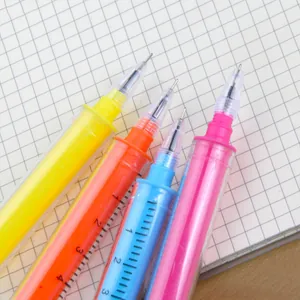 Set of creative syringe shaped gel pens in vibrant neon colors on grid notebook paper
