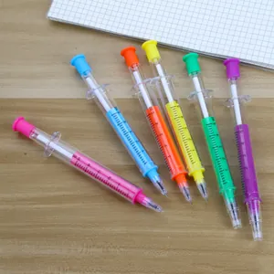Creative multi-colored syringe-shaped gel pens arranged on a desk with a notebook