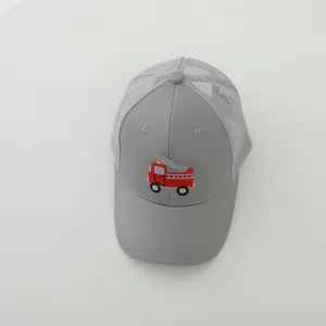 Detail view of children's mesh baseball cap with embroidered red fire truck design.