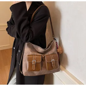 Vintage brown hobo bag with denim texture and dual front pockets for women