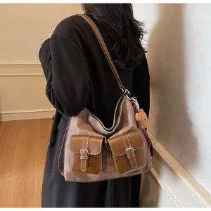 Large trendy denim-texture hobo shoulder bag with front pockets and teddy bear charm