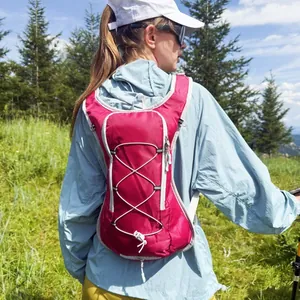 Magenta lightweight outdoor hydration backpack shown in a hiking scenario on model
