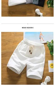 Close-up of white cotton linen shorts with drawstring and bead details